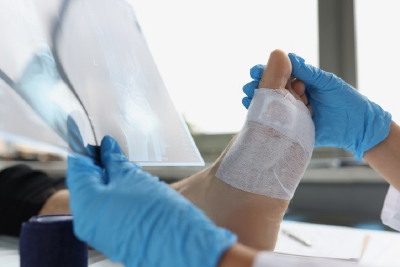 A doctor examines a bandaged foot during a consultation in John J Williams, DE